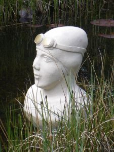 stone carving of the head of a swimmer emerging from the water